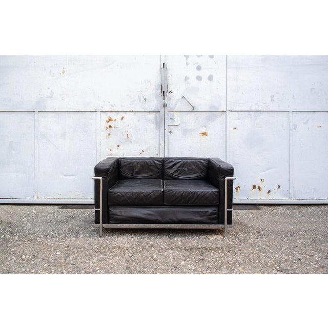Two-seater sofa with chromed metal structure, padding covered in leather. LC2 model Designer Le Corbusier Manufacturer...