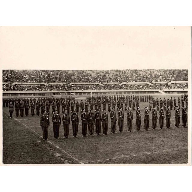 Military show in the stadium is an original black and white photograph realized by an Anonymous photographer in 1930s in...