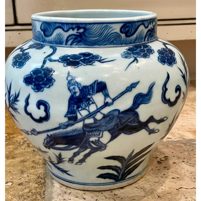 This jar has a very small base that curves gracefully upward. It has detailed depictions of warriors and their weapons of...