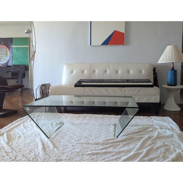 There are few manufacturers of this sleek bent glass table. This table is unique in it's height of 15.5" inch and depth...
