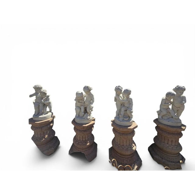 Charming set of four sculptural groups depicting putti, expertly carved in Italian marble during the second half of the...