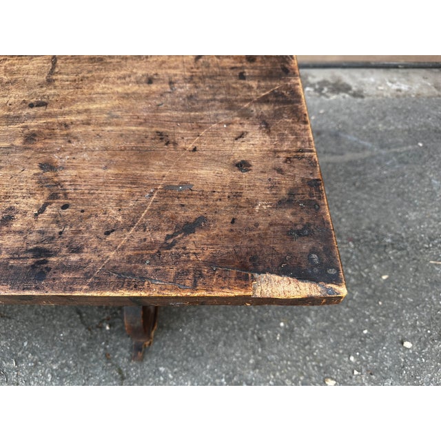 This is an antique rustic trestle bench (sometimes called a "water bench" or "fireside bench"), most likely dating from...