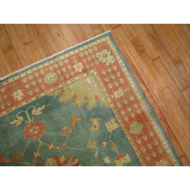 An exhilarating accent size early 20th century antique Turkish Oushak rug with a vivid green field and orange border....