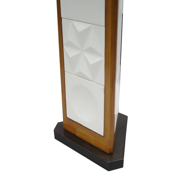 A pair of Modernist table lamps designed by George Nelson. Triangular stem in walnut with matte white decorative ceramic...