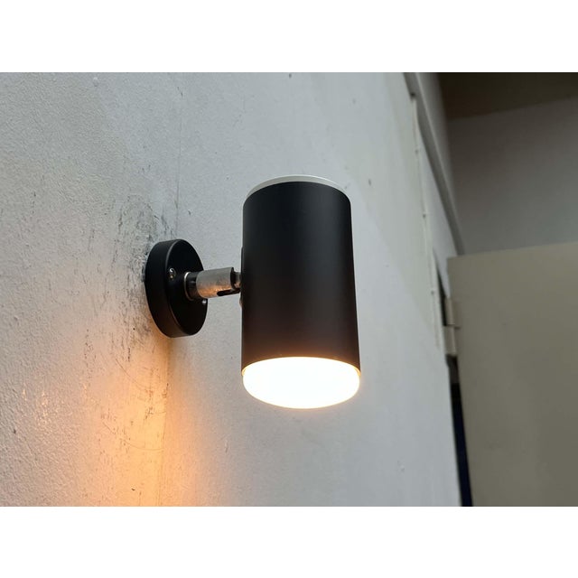 Minimalist wall lights by beisl. a functional design with a minimalist aesthetic. The light head is a black cylinder. The...