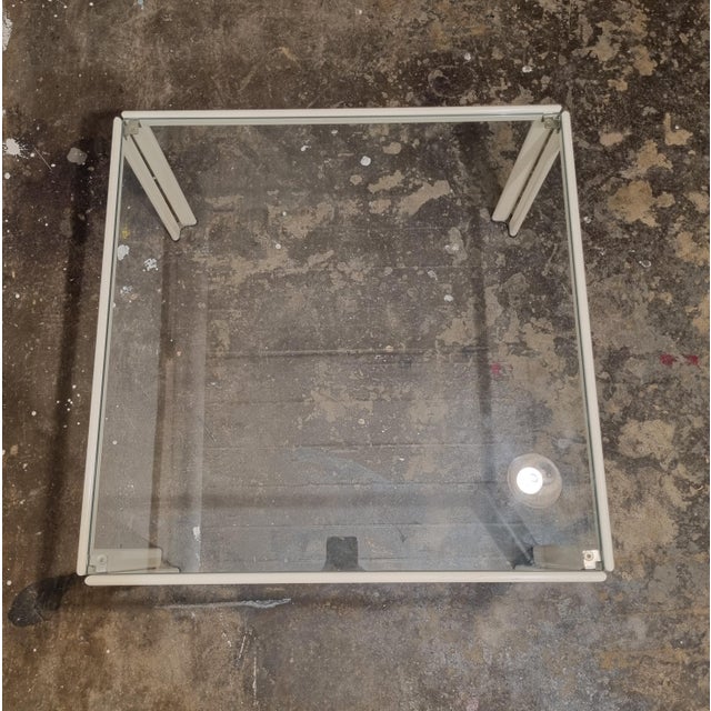 Small coffee table that also could be used as a corner or side table. Made from white lacquered metal it has a glass top....