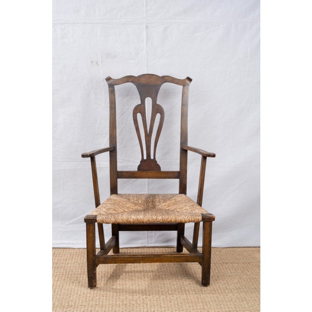 A Country Chippendale style rush seat armchair, early 20th century, American. Features a rush seat and simplified details...
