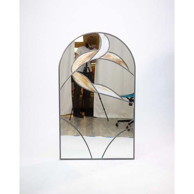 A vintage 1973 stained glass wall mounted mirror. This vintage mirror features a large rounded rectangular shape with a...
