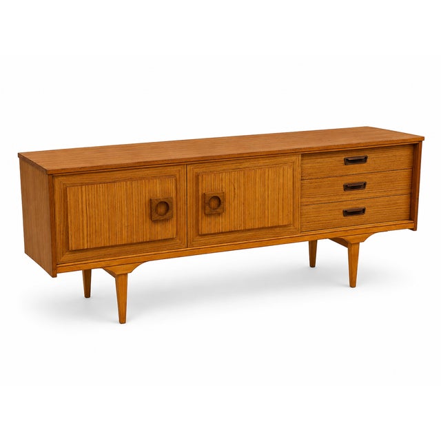 A beautifully restored mid-century blonde sideboard, featuring a striking striped wood veneer, sliding cupboard doors and...