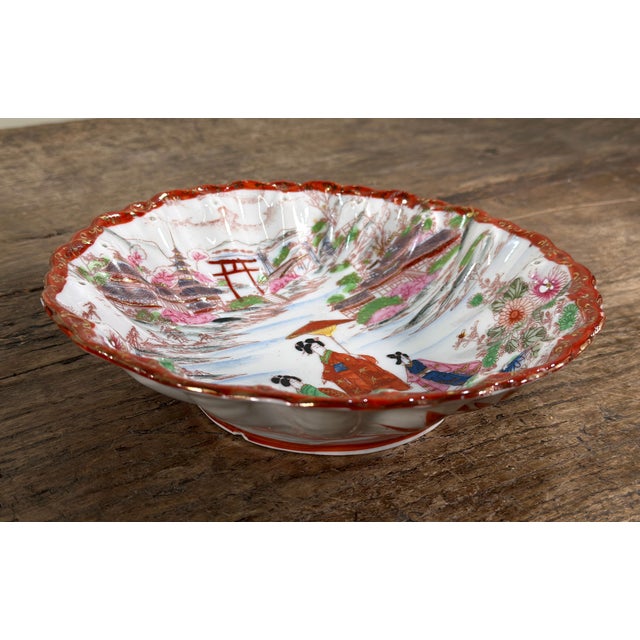 This vintage mid 20th century Japanese porcelain bowl features hand painted decoration depicting three geisha figures in...