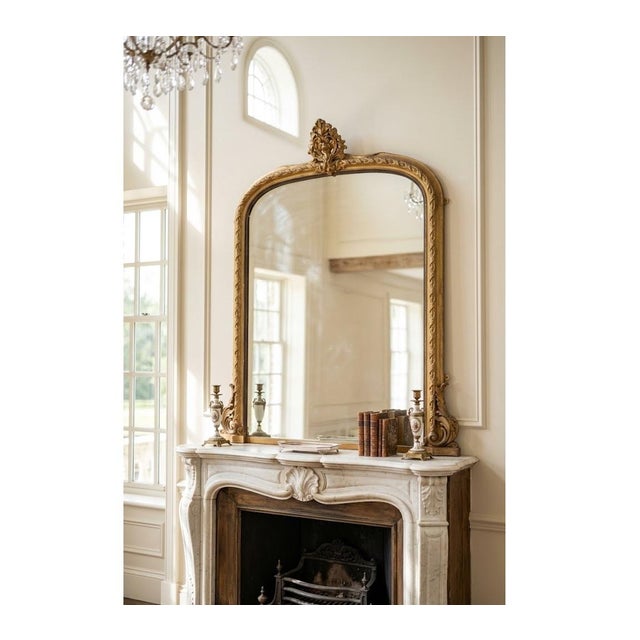 A large 19th-century giltwood wall mirror (circa 1860), commanding attention with its impressive scale, classic arched...