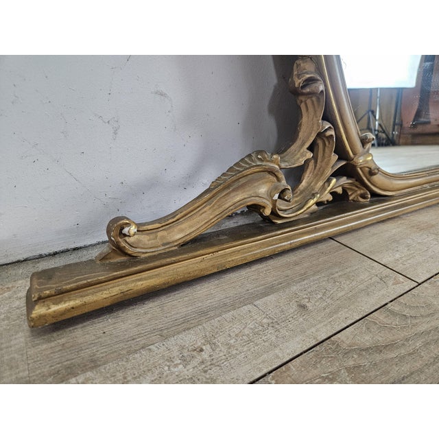 Large vintage 1960s mirror in gold-lacquered wood with carvings and contours along the edge. Perfect as a decorative...