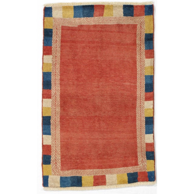 Hand-knotted Persian Lori wool rug featuring a red field framed by a patterned inner guard border and a multicolored block...