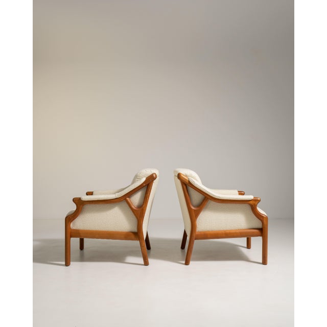 A stylish pair of Danish armchairs featuring soft bouclé upholstery and clean, modern lines. Scandinavian design...