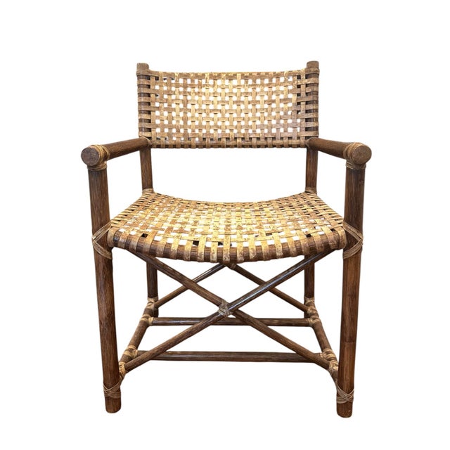 A beautiful, rustic armchair by McGuire Furniture. Features a stained rattan frame with seat and back crafted of laced...