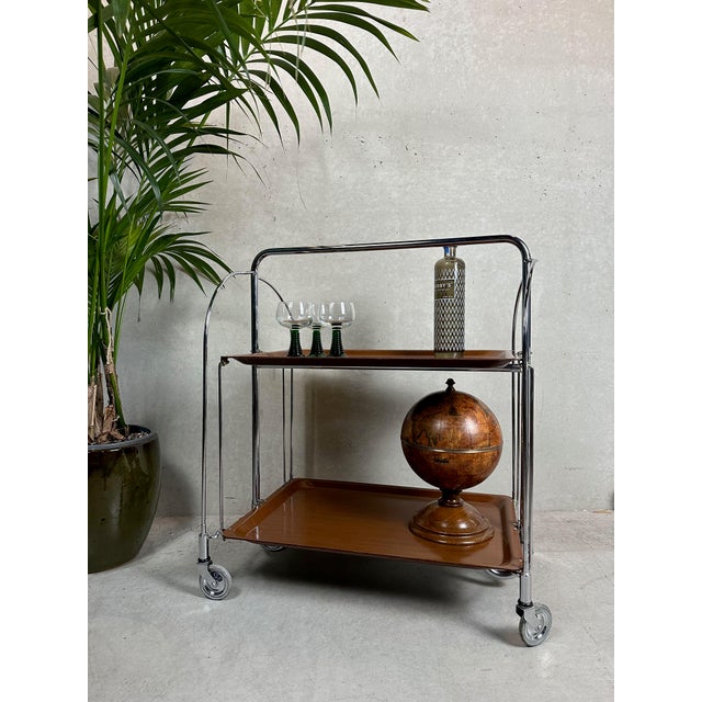 Handy vintage serving trolley made of metal (chrome) and plywood. It has a slightly industrial look. Marked: Gerlinol....