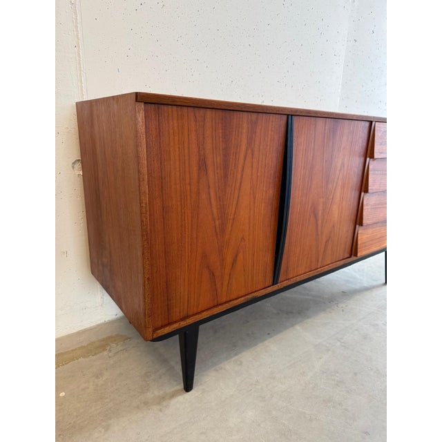 Exceptional mid-century teak sideboard with black details from the Swedish company Bräntorps, 1950s-60s. This piece has an...