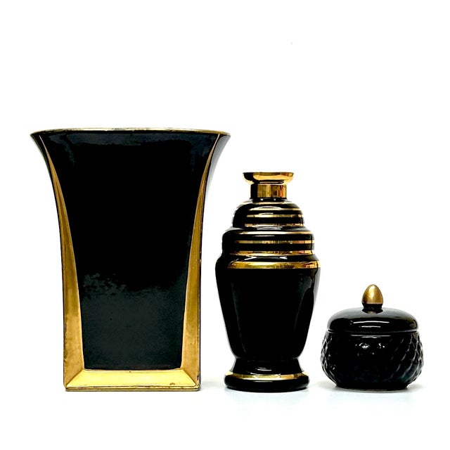 Black and gold ceramic vessels, group of 3. A beautiful set of art deco ceramic and glass embellished vessels in a variety...