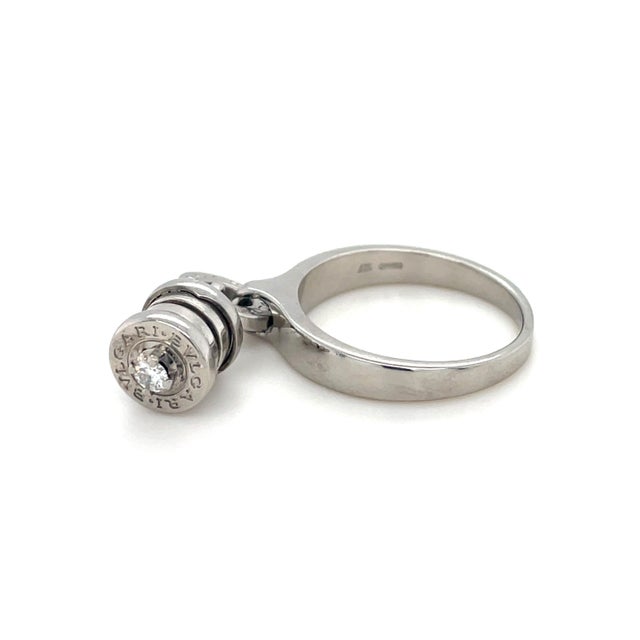 From the classic B.zero1 Collection, this ring contains an engraved Bulgari hoop suspending a dangling charm with round...