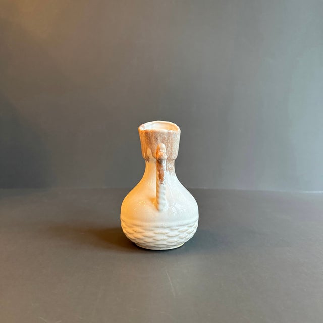 This charming vintage ceramic creamer pitcher adds a touch of rustic elegance to any kitchen or dining space. Featuring a...