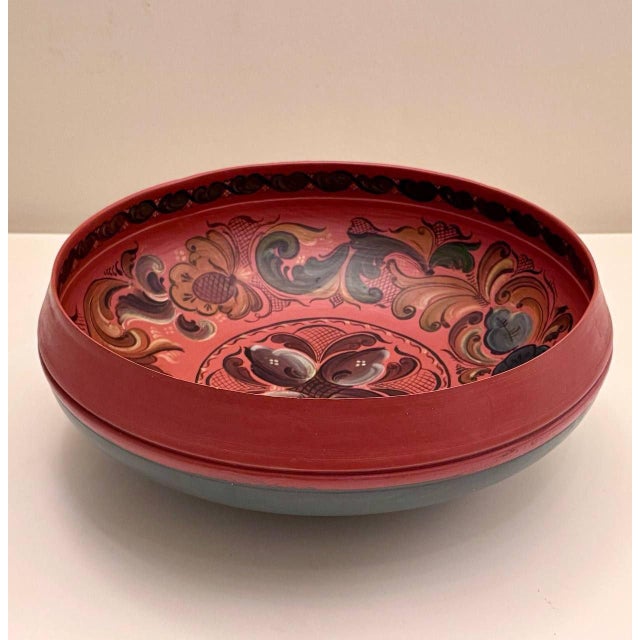 A striking vintage Norwegian wooden bowl, hand-painted in the traditional Rosemaling folk art style. The bowl features a...
