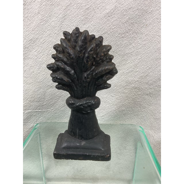 Cast iron doorstop with old black paint. Some areas of paint loss and rust,especially on the bottom. 7” tall 3 1/2” wide...