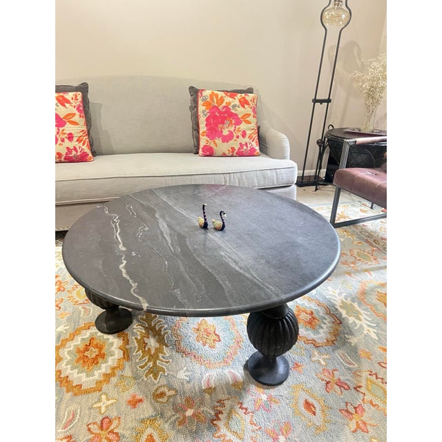 The Anthropologie Caria Coffee Table features a substantial solid marble top paired with a sculptural handcarved mango...