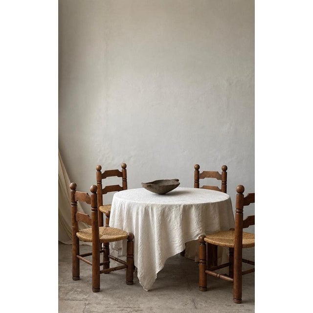 A set of four French Modernist dining chairs, attributed to Charles Dudouyt and dating to the 1940s–1950s. Made from solid...