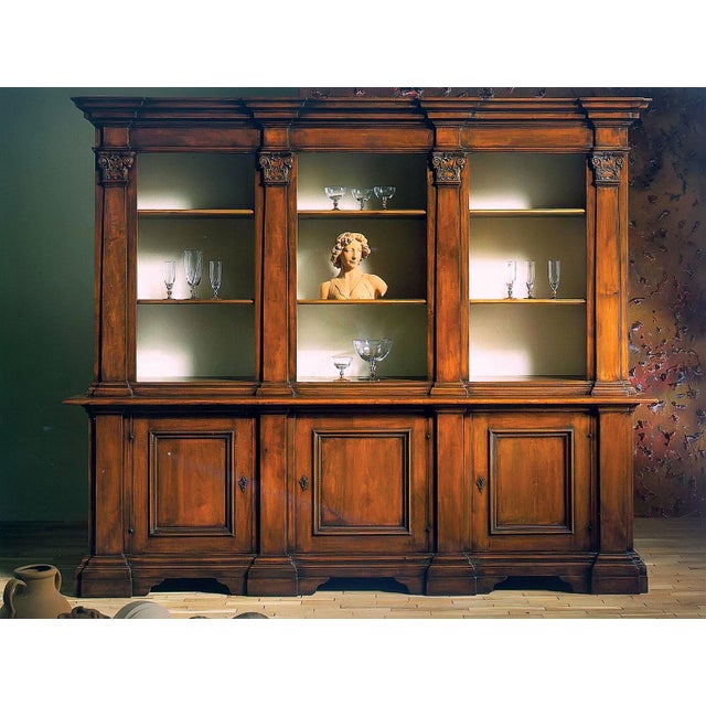Handcrafted in Italy from solid walnut, this three-section library cabinet features an antique distressed finish and...