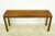Mid Century style walnut rectangular shaped console table with a dark stain. The table features a classic style, with a...