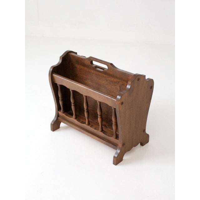 A charming Colonial Revival magazine rack crafted in warm-toned wood, featuring delicately turned spindle sides and softly...