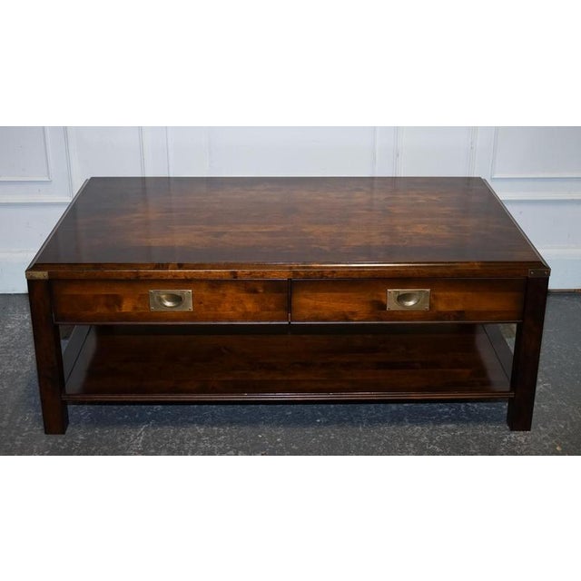 A smart and characterful vintage military campaign coffee table, crafted from richly toned wood and finished with classic...