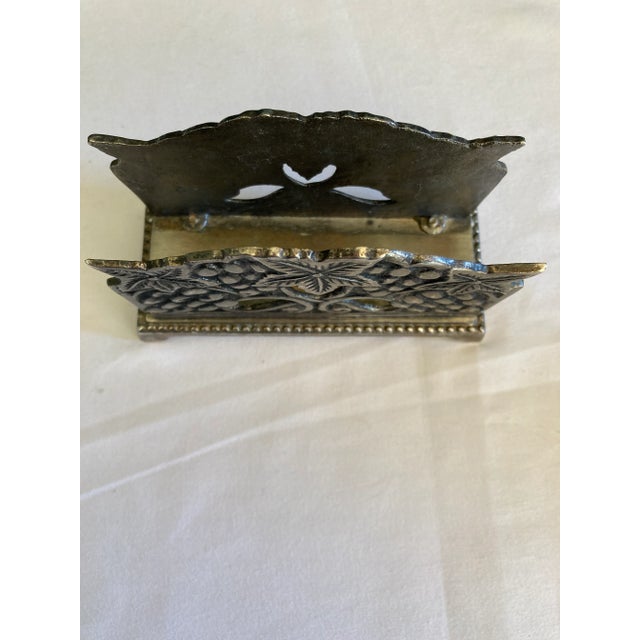 This vintage cast metal letter holder showcases an ornate grape and leaf design with sculptural detailing and a warm aged...