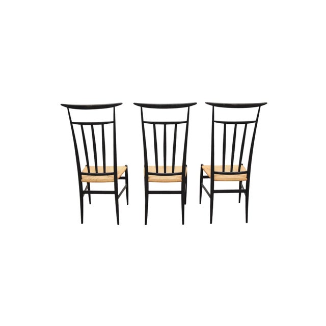 Mid-century Chiavari-style chair with a tall, slender ebonized wood frame and woven rope seat. The elongated back features...