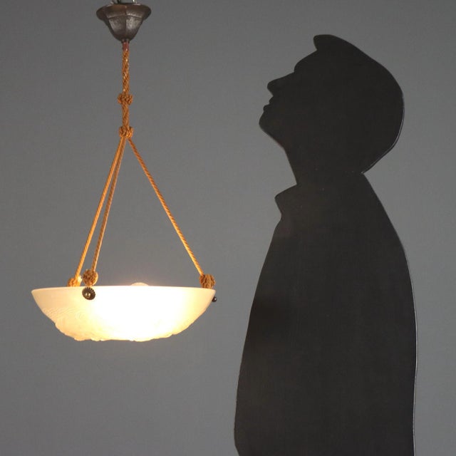 White glass chandelier by Artistar France, dating to the first half of the 20th century. The bowl, crafted in glass...