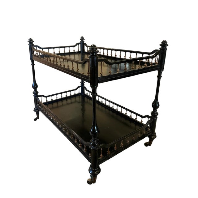 A lovely, old two-tier cart or étagère, with a Madeleine Castaing, bohemian-Victorian vibe. Its ebonized finish is paired...