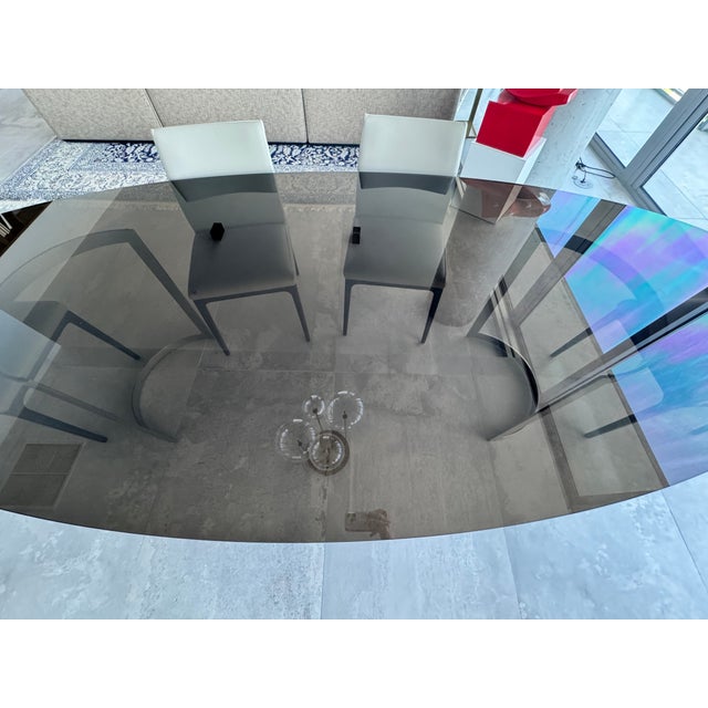 Artefacto brand Elegant contemporary dining table by Artefacto featuring a substantial smoked tempered glass oval top...
