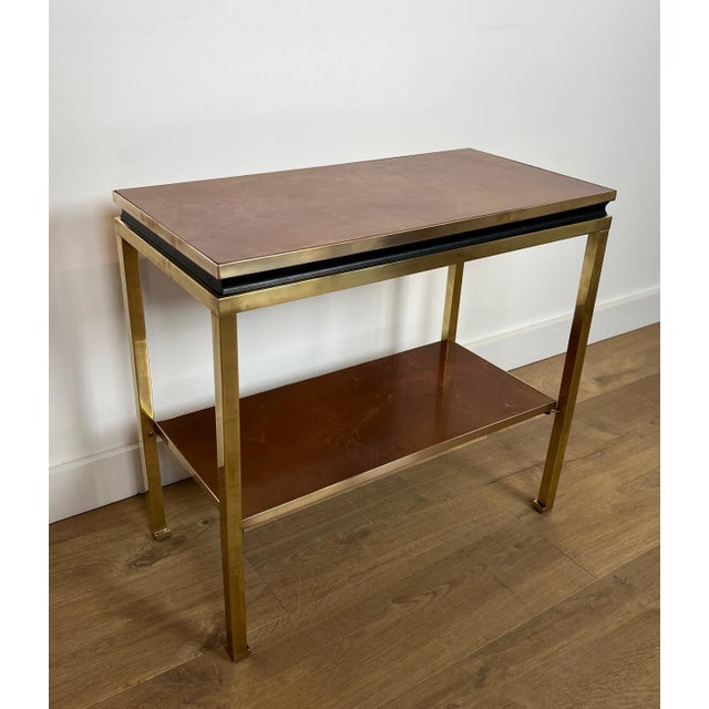 This beautiful and elegant side table or console is made of brass and black lacquered metal with shelves in Amber...