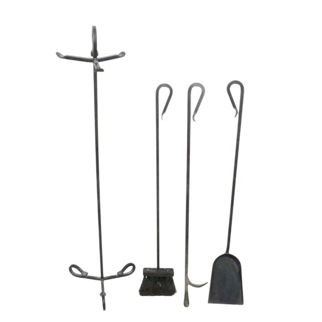 Vintage four piece wrought iron fireplace tool set consisting of a poker, brush, shovel, and stand. The set is in very...