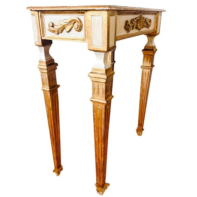 Mid-century Italian-style console table crafted with hand-carved wood accents and featuring fluted tapered legs...