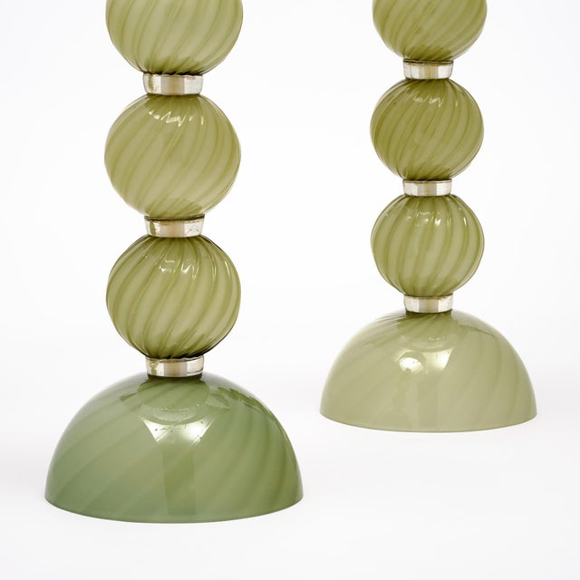 Pair of lamps of Murano glass from Italy. These lamps feature spheres of swirling hand-blown glass on a glass base in a...