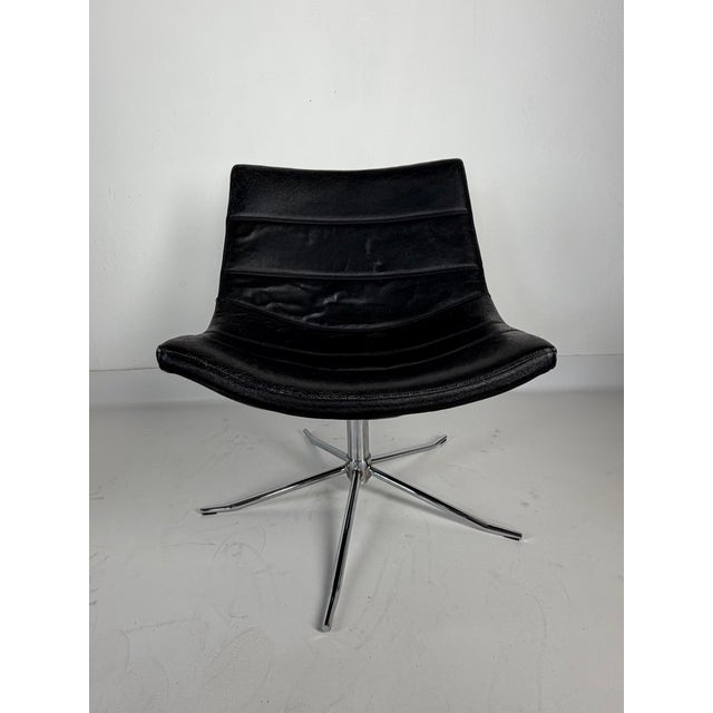 Vintage swivel lounge chair featuring a low, wide scoop-style shell, without armrests, set on a chrome-plated swivel base....