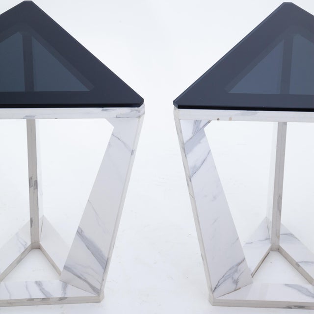 Stylish pair of Italian Modern triangular side tables. Bases are made with polished statuary marble, cut in dynamic...