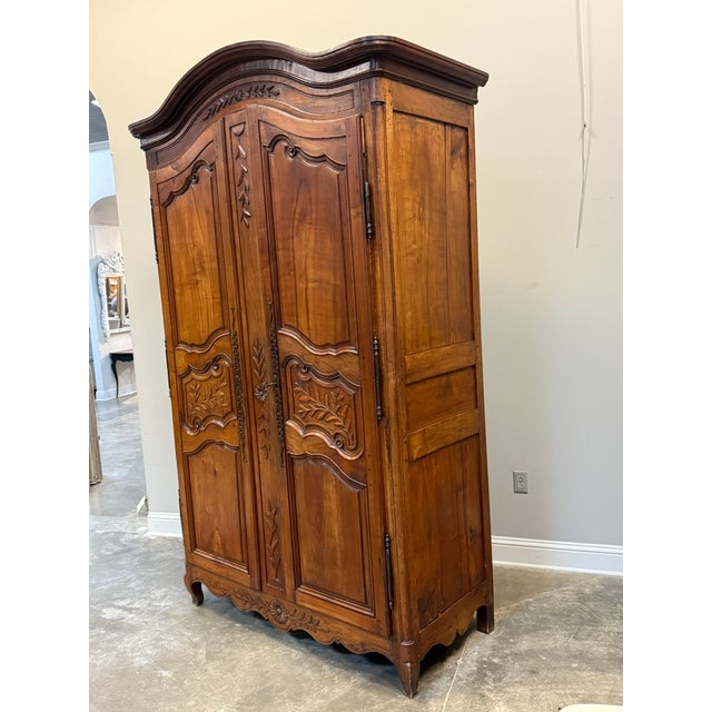 19th C. French Provincial Louis XV style armoire in walnut with foliate carvings on the doors and cornice. These pieces...