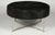 A Mid-Century Modern cow hide upholstered round bench or ottoman raised on a metal X-form base.