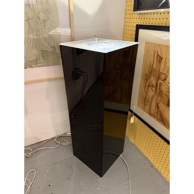 Sleek and architectural, this mid-century illuminated pedestal transforms the act of display into a dramatic visual...