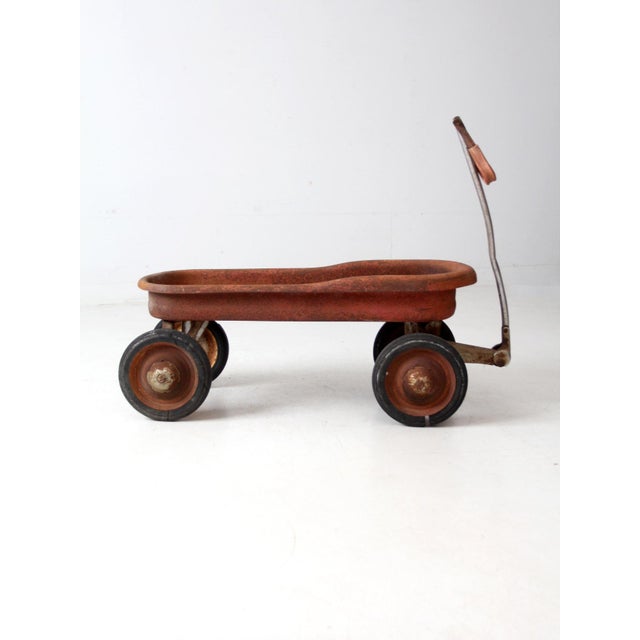 This vintage red metal pull wagon dates to the 1930s and closely resembles early Murray Mercury models. The front wheels...