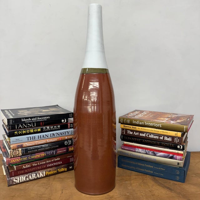 "About This Piece About This Piece This dramatic tall vase captures attention instantly, its soaring neck and warm,...