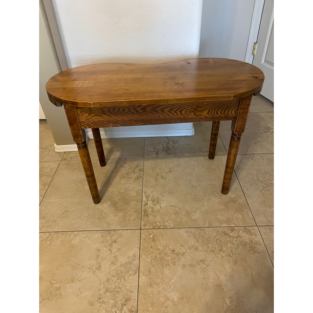 A vintage kidney-shaped wood accent side table, typically crafted from pine or tiger oak. Features a classic curved kidney...