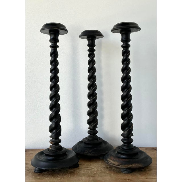 This exceptional set of three vintage barley twist candlesticks is a masterful celebration of traditional English design...